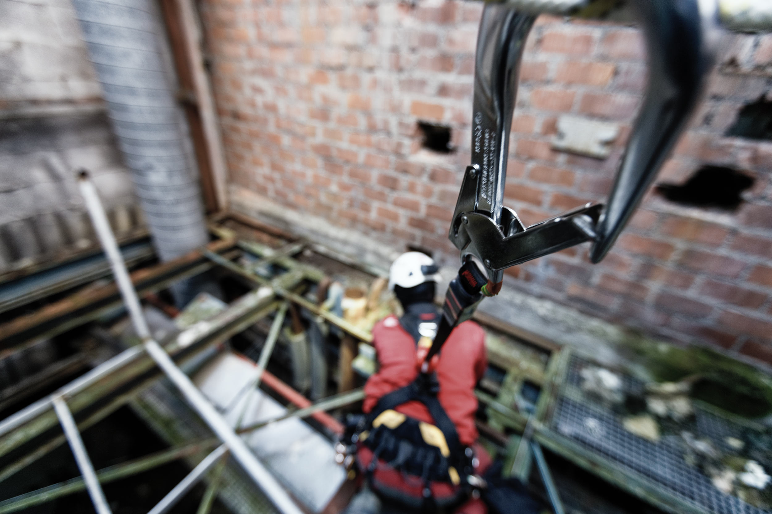 Travailleur en hauteur en formation équipé d’un harnais relié par un enrouleur automatique. 