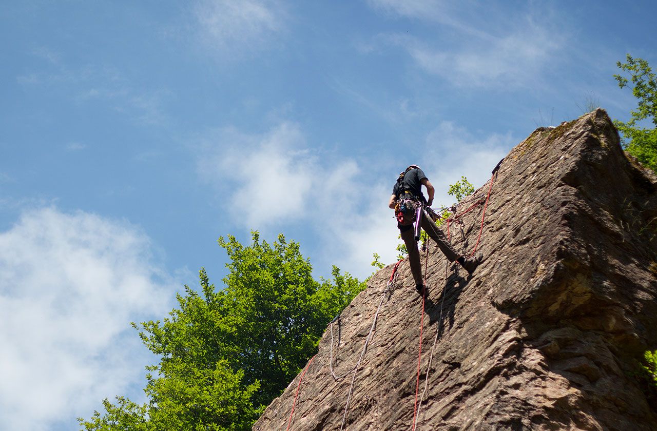 cordiste en progression sur une paroi rocheuse avec cordes de sécurité