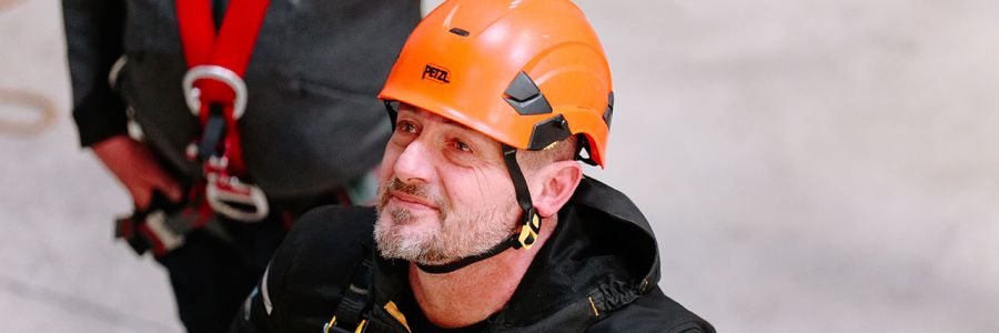 image d'un cordiste qui observe des opérateurs en action