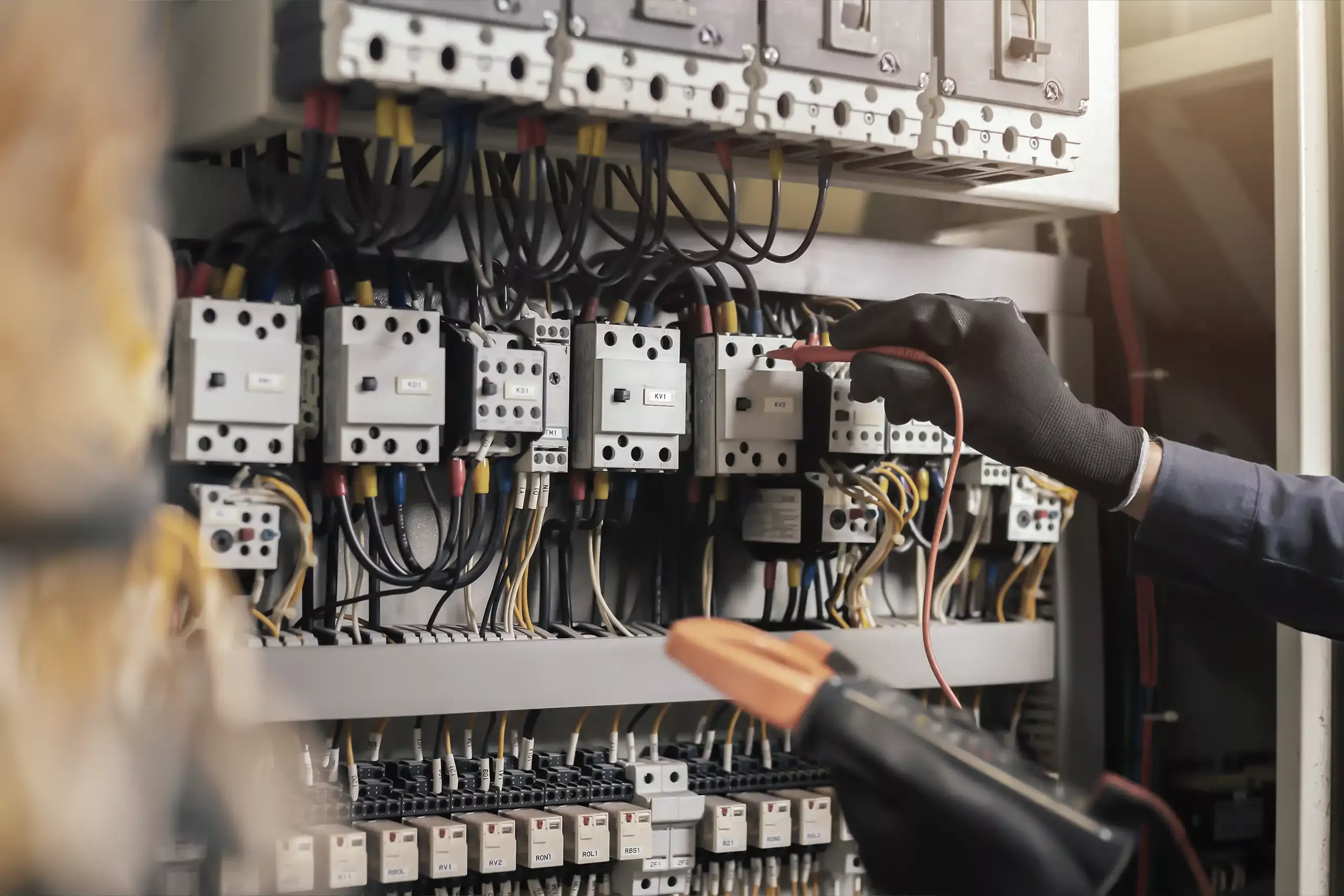 Technicien effectuant une vérification électrique sur une armoire de commande — formation habilitation électrique Jarnias Formation
